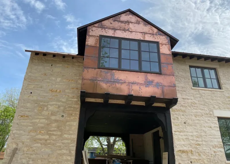 Copper metal panel facade on a stone building for Roof Repair in Live Oak